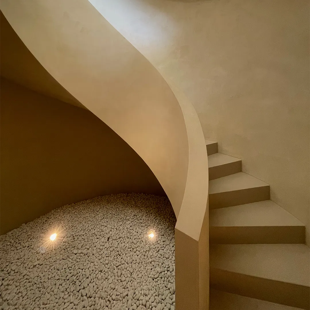 A curved staircase against a wall finished in Clay®