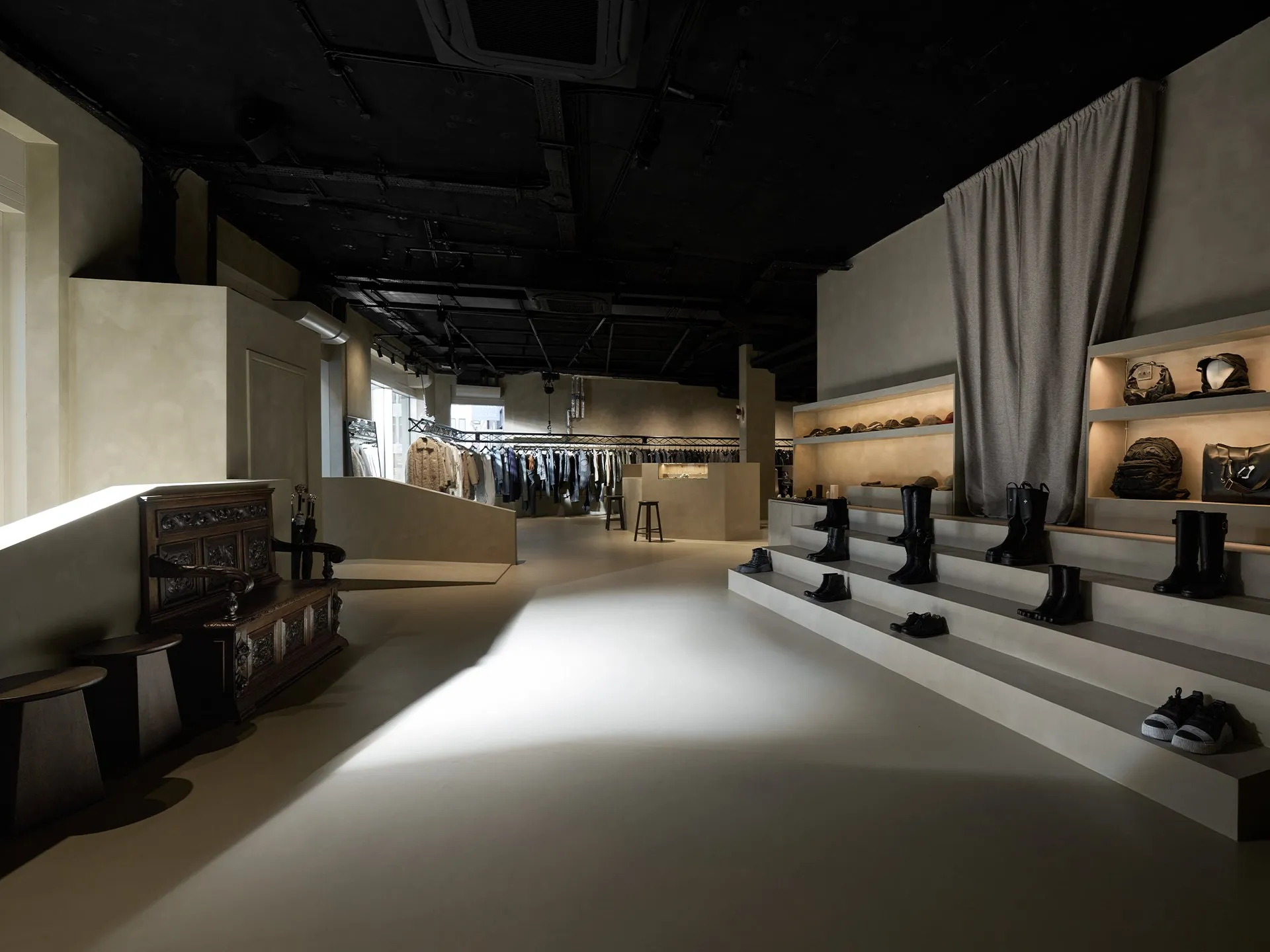 Interior comercial oscuro con superficies continuas y mobiliario expuesto
