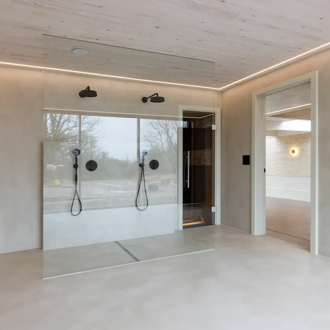 An open bathroom with a double shower and a seamless Ecocemento® floor