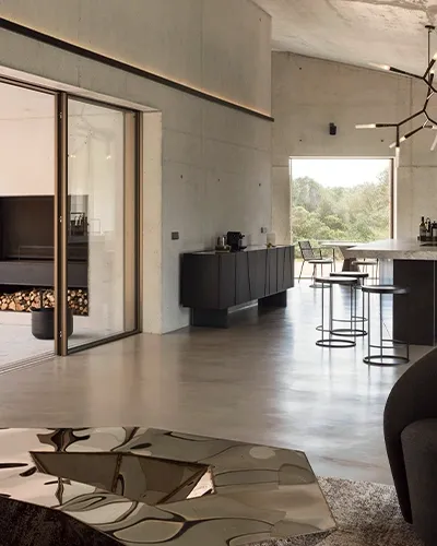 Salón y cocina de una vivienda con suelo continuo de microcemento