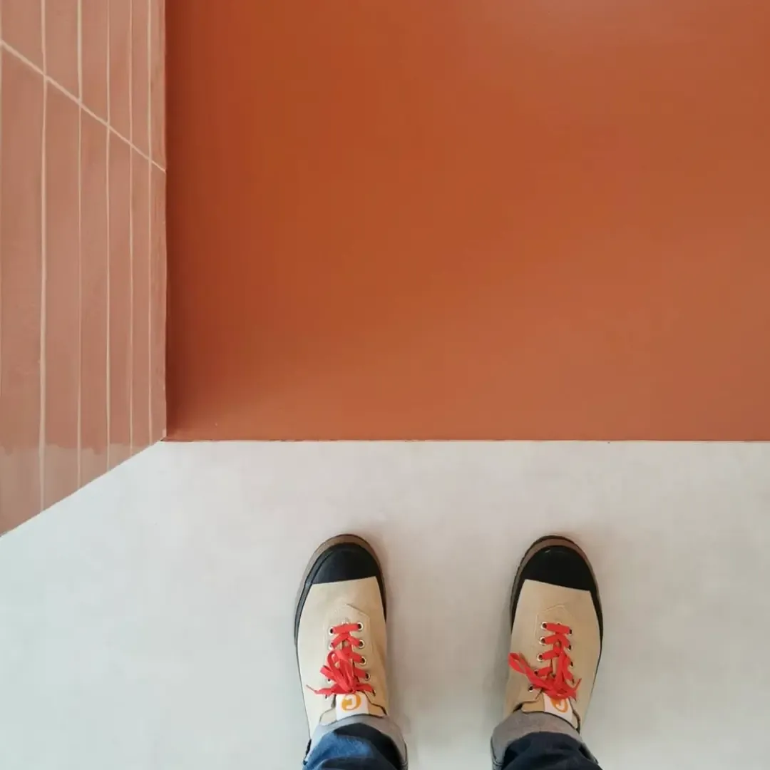 An underfloor heated Summery® floor against a terracotta wall